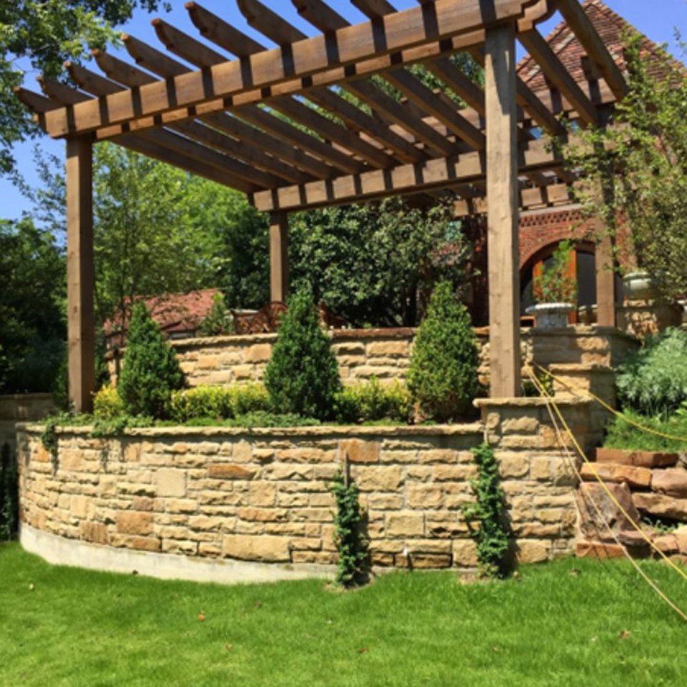 Landscaping services Dallas TX team installing fresh plants, mulch, and clean garden borders outside a neat residential property.